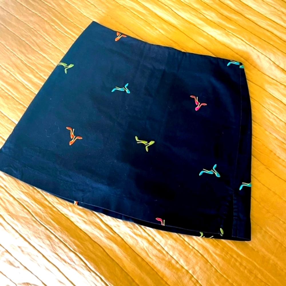 COPY - Black adorable golf skort with various colors of heels.